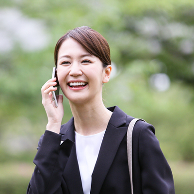 スマートフォンで電話する笑顔の女性