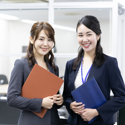 ファイルを抱えたスーツ姿の女性の二人組