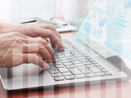 ラップトップPCを扱う手元にオーバーレイする折れ線グラフ