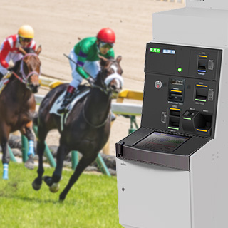 競技中の競馬を背景にした投票券券売機