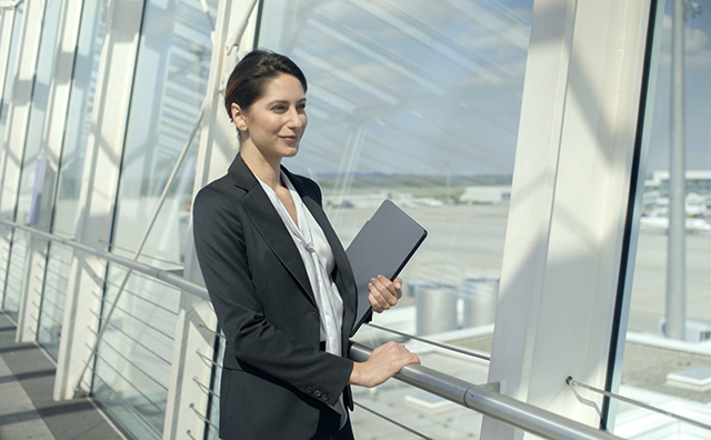 Professional woman standing inside a modern airport terminal