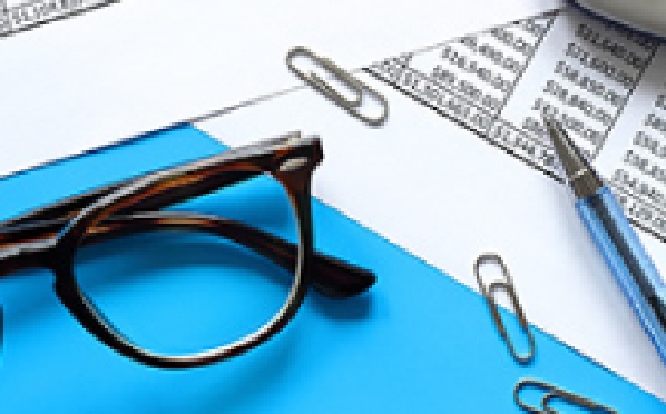 Bild von verstreutem Papier, Büroklammern, Brille und Stiften