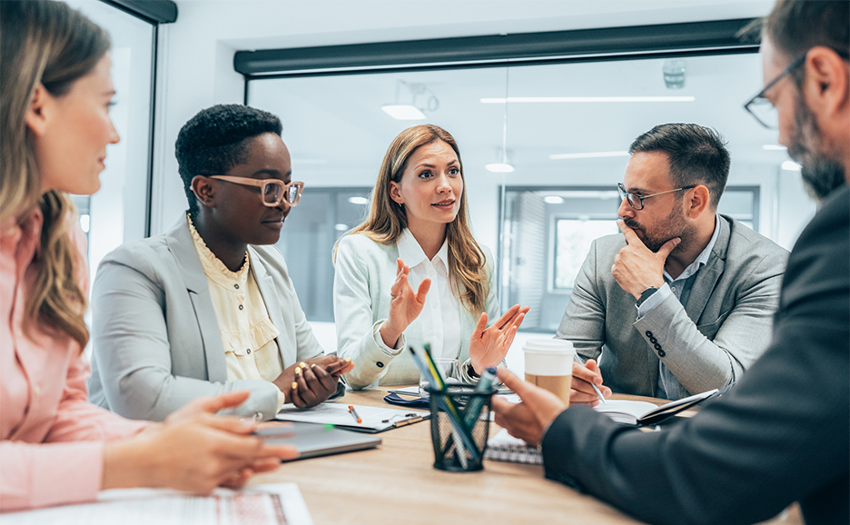 Picture of business people of various races sitting around a table in a conference room