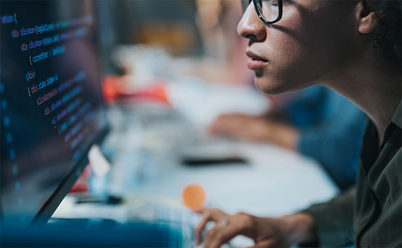 Person reading computer code on a desktop PC