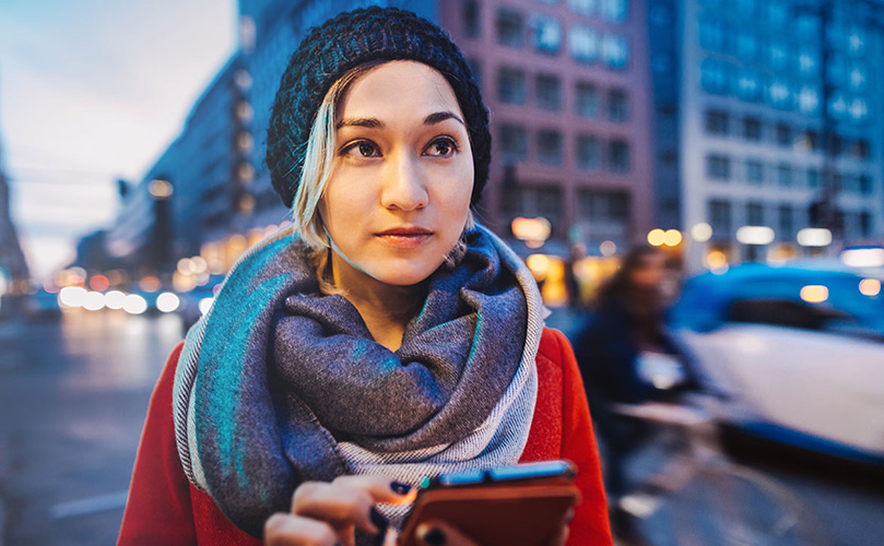 Woman using mobile phone in a street