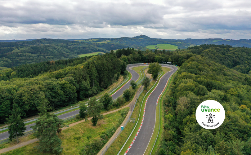 a winding road with trees and hills in the background