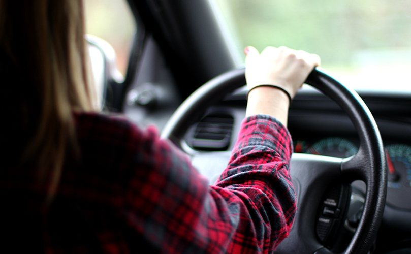 車のハンドルを持って運転する女性