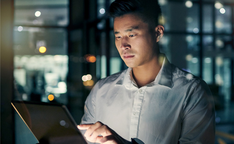 Young businessman working in a modern office on digital tablet