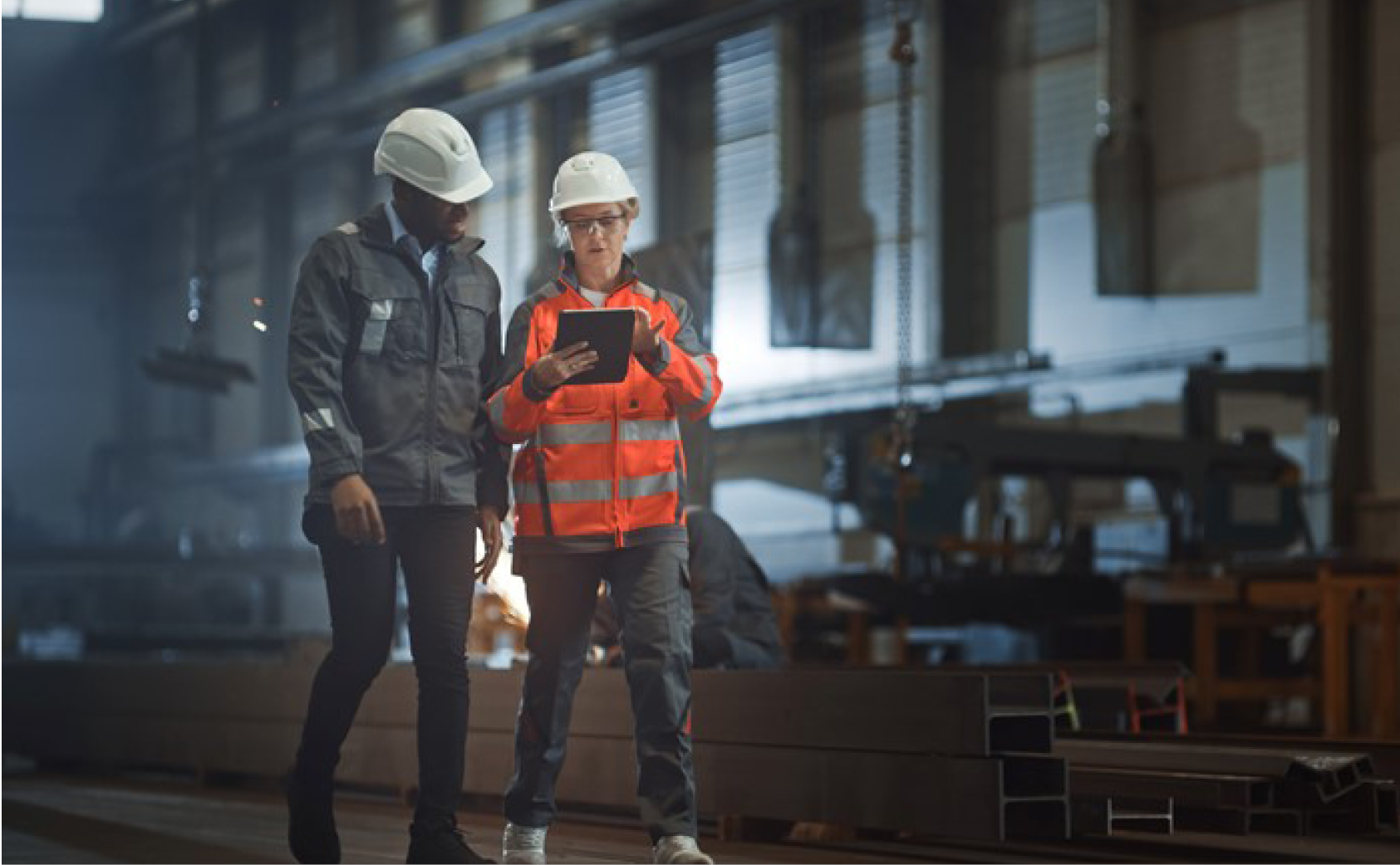 Two male workers discussing over a tablet in a factory