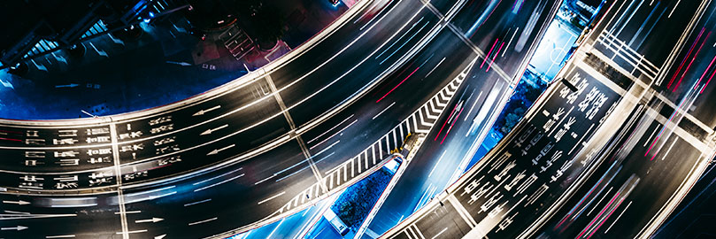Aerial view of a complex highway interchange at night.