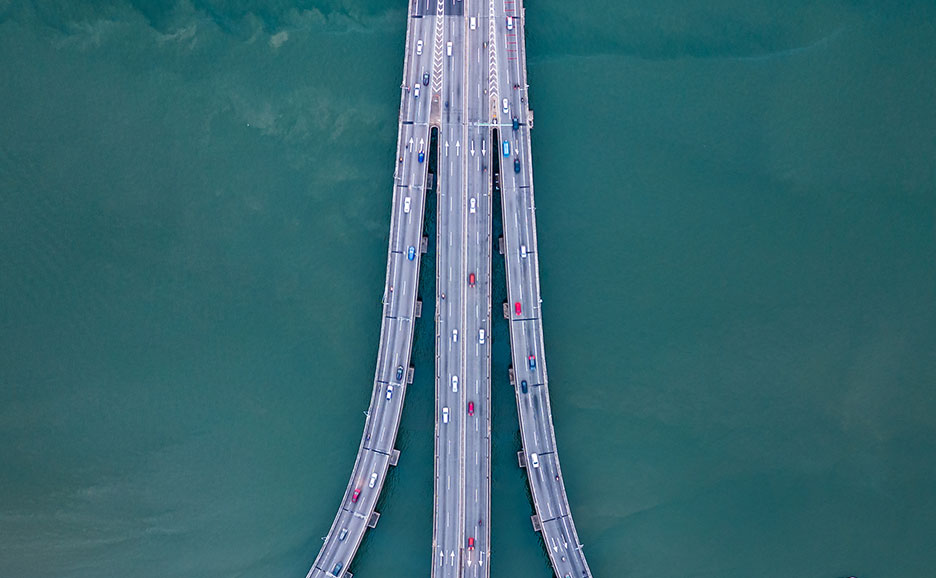 Aerial view of a bridge over water with cars.