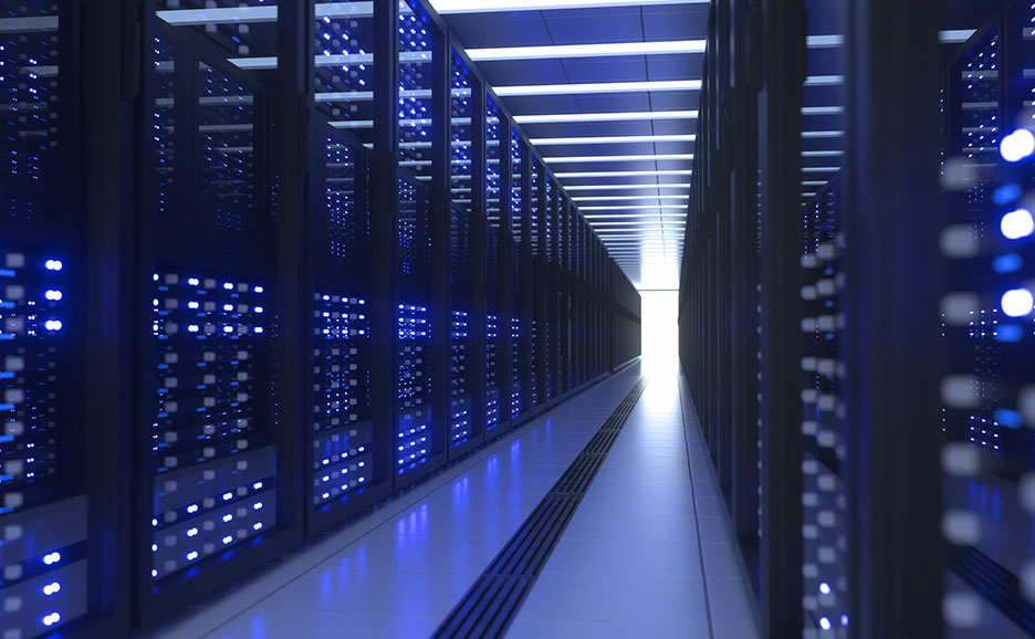In a server room, server racks lined on both sides emit blue light.